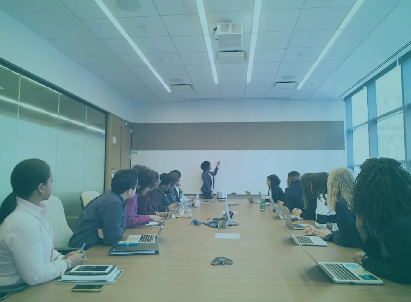 how-to-build-an-infinite-team-featured-1 Business team in conference room watching a presenter at a whiteboard