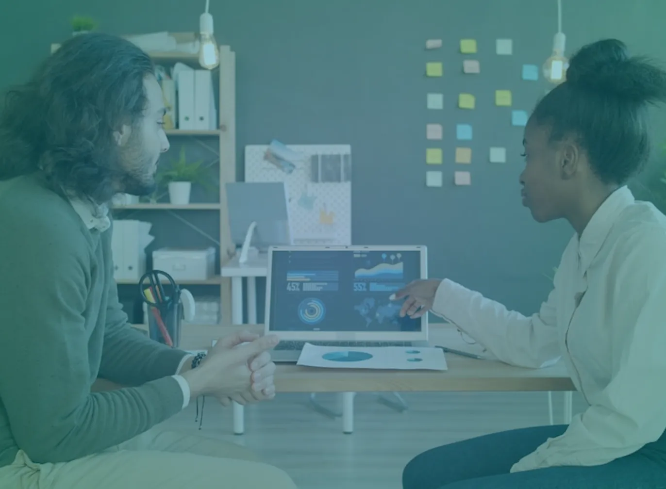 Two colleagues reviewing sales pipeline data together on a laptop