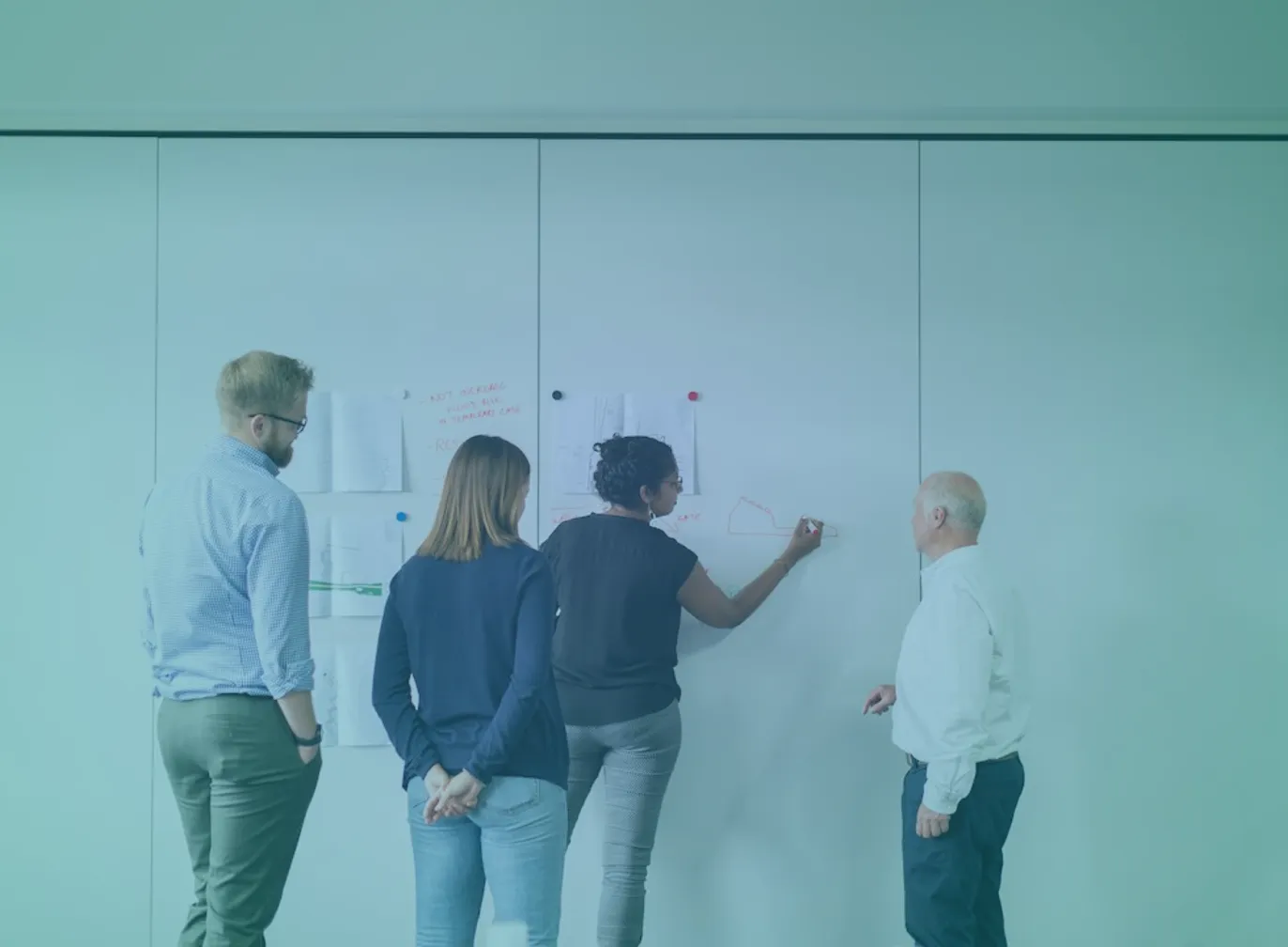 b2b-marketing-consultant-featured Four colleagues planning at a whiteboard, illustrating the diagnostic work that comes before hiring a B2B marketing consultant